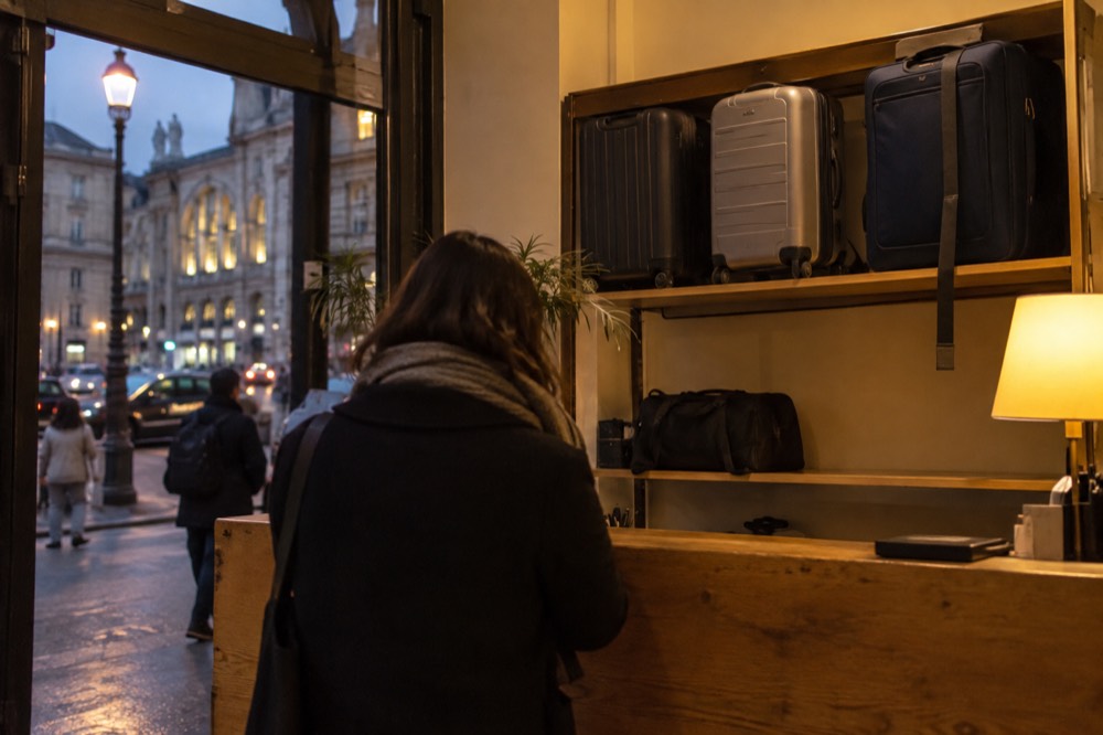 Suitcases lined up behind a shop counter in the evening under warm lighting