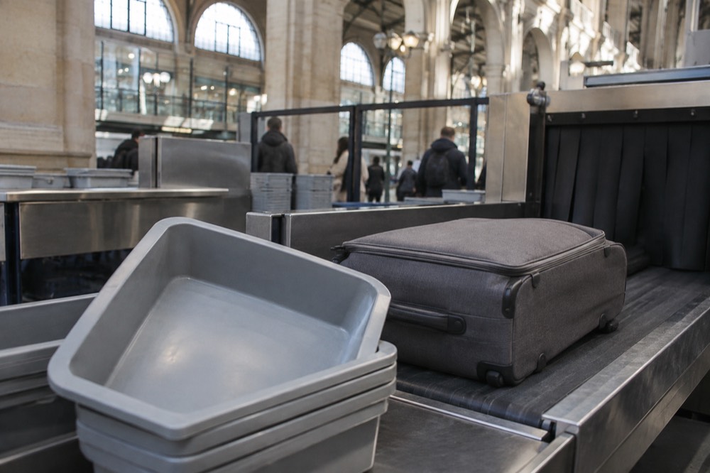 A suitcase and trays at an airport security screening belt near Paris