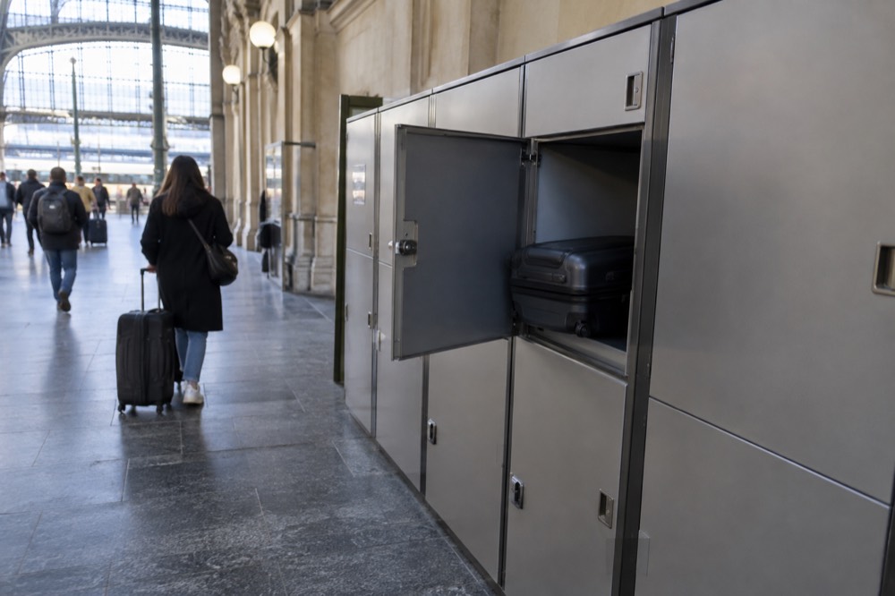 A row of storage lockers along a wall in a brightly lit station corridor