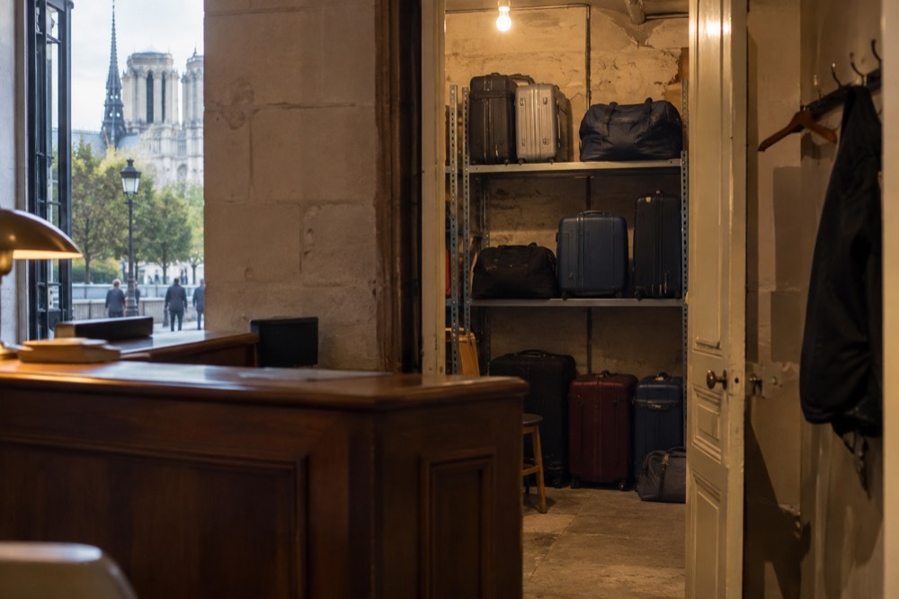 A hotel luggage room in Paris with shelves and a few stored suitcases