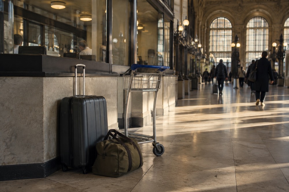 Left-luggage counter at an airport terminal with a staffed desk and baggage tags