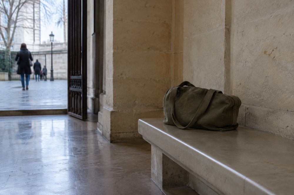 A museum entrance hall with a small bag sitting on an empty bench