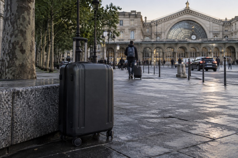 A suitcase on the forecourt outside a Paris mainline station in the early morning