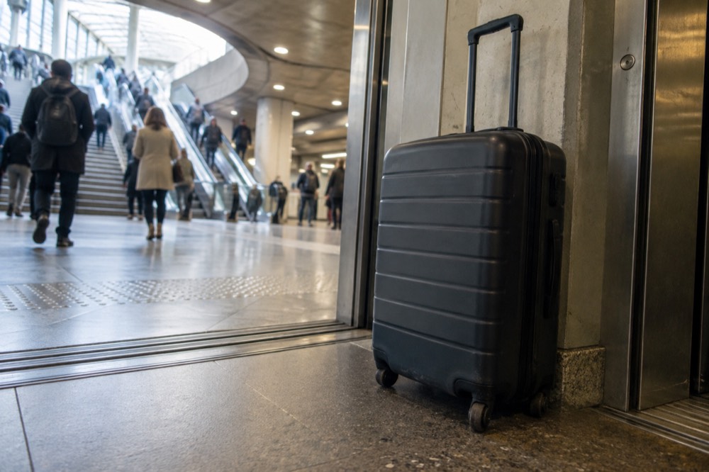 A wide Metro platform with a lift door open and a suitcase beside it