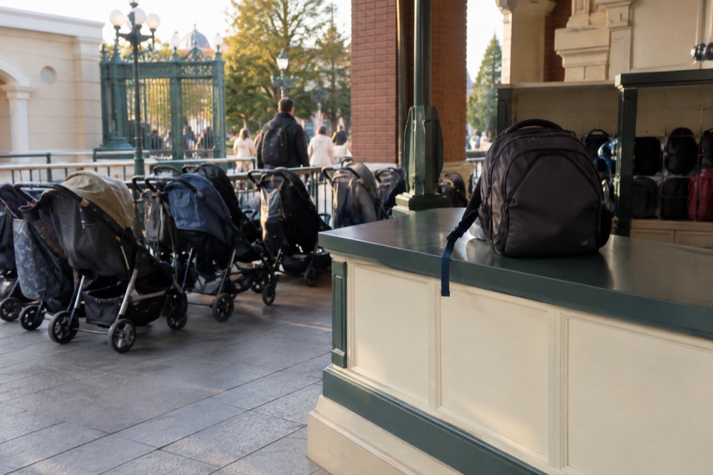Storage counter beside a theme park entrance with strollers parked alongside