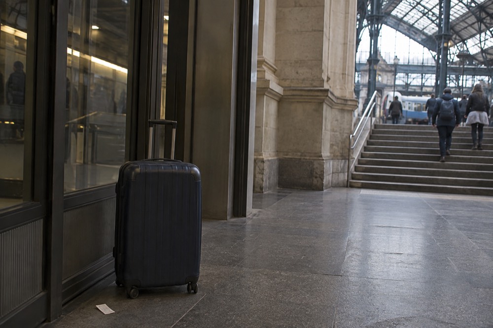 A Metro platform in Paris with a suitcase waiting beside the platform doors