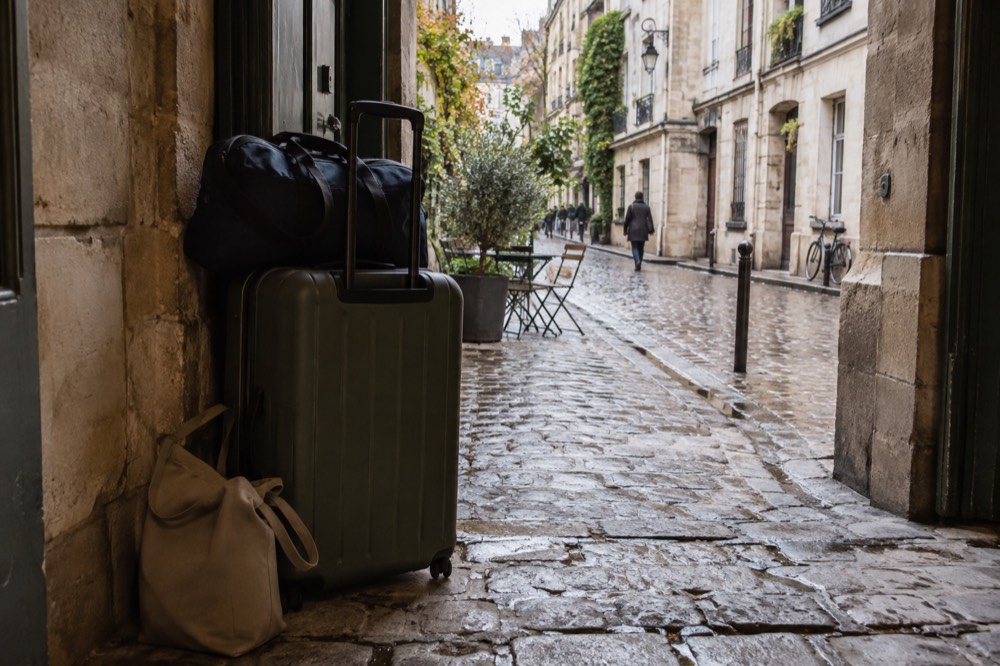 A Paris street corner with a small shop entrance where bags are stored