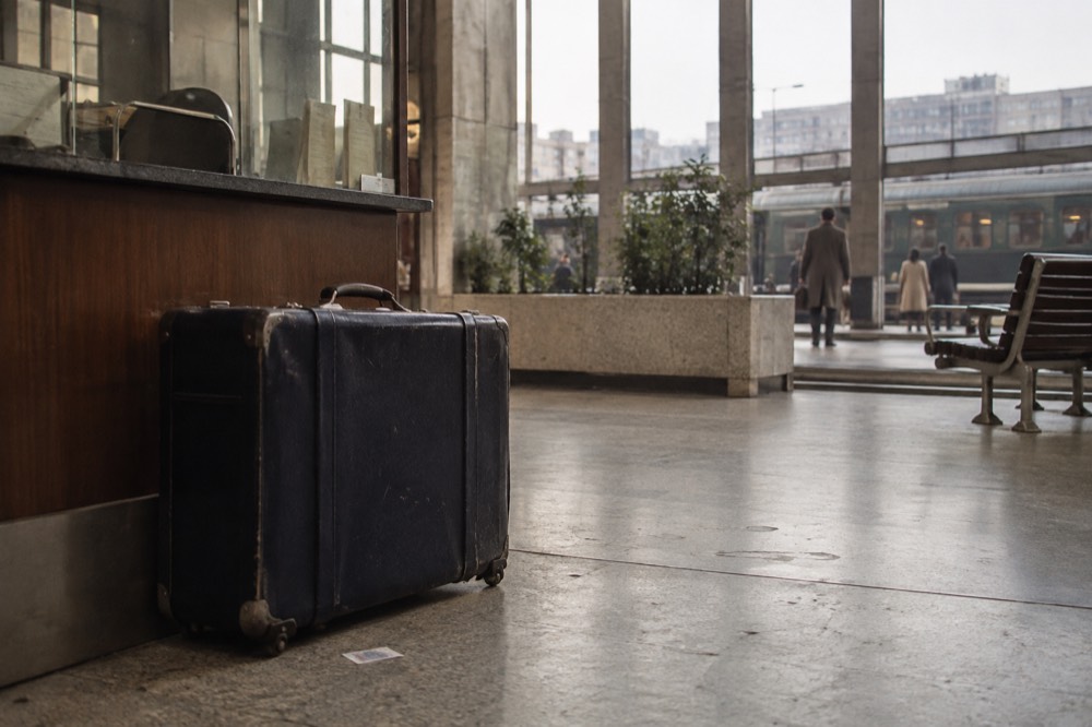 A suitcase standing alone beside an information desk in a Paris station