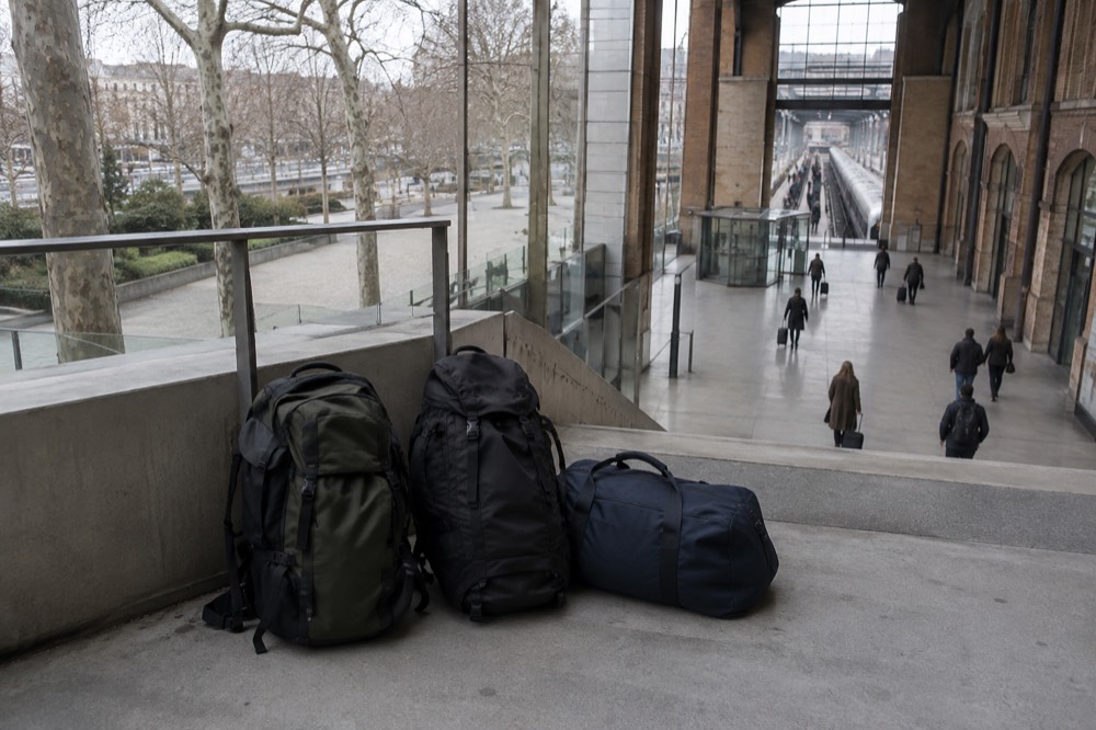 Modern glass station hall with travellers walking and no visible lockers