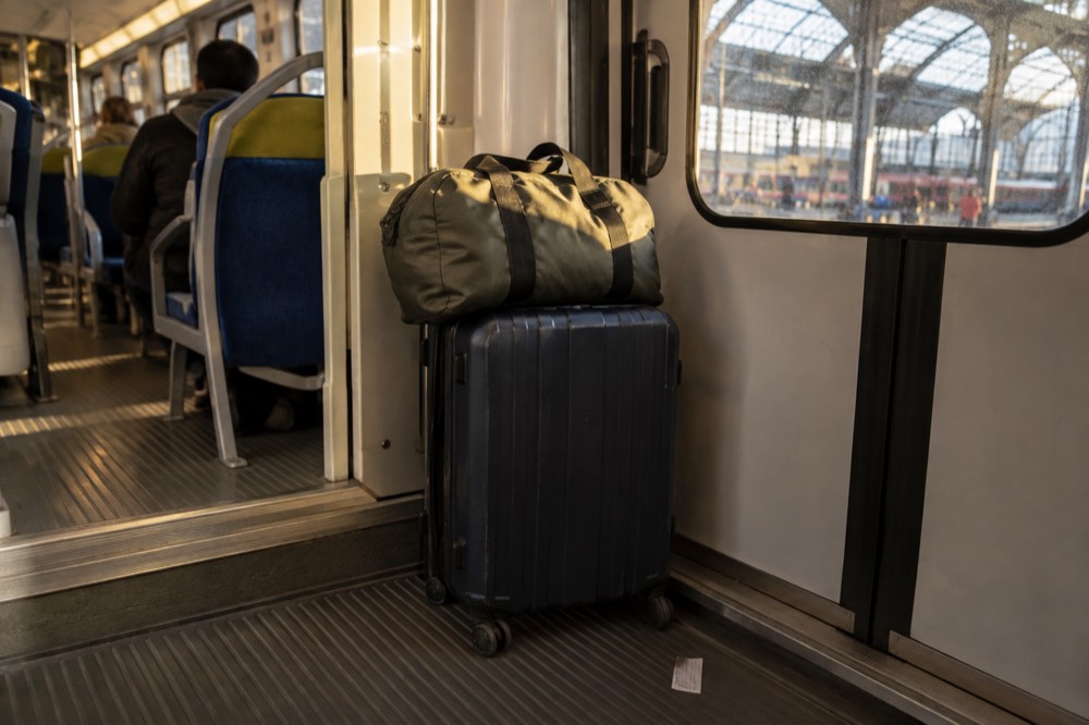 Suitcases stacked in the door vestibule of a double-decker Paris commuter train