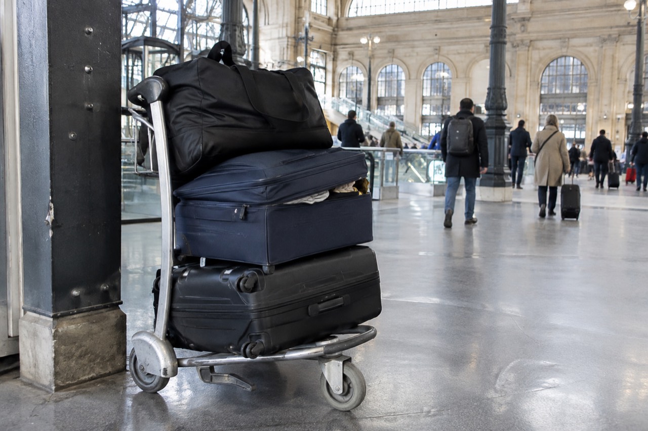 A luggage trolley loaded with cases parked beside a pillar in an airport concourse near Paris