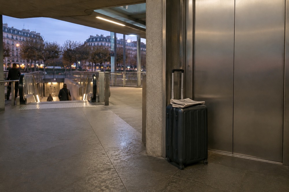 A suitcase beside the lift doors on a modern Paris Metro platform