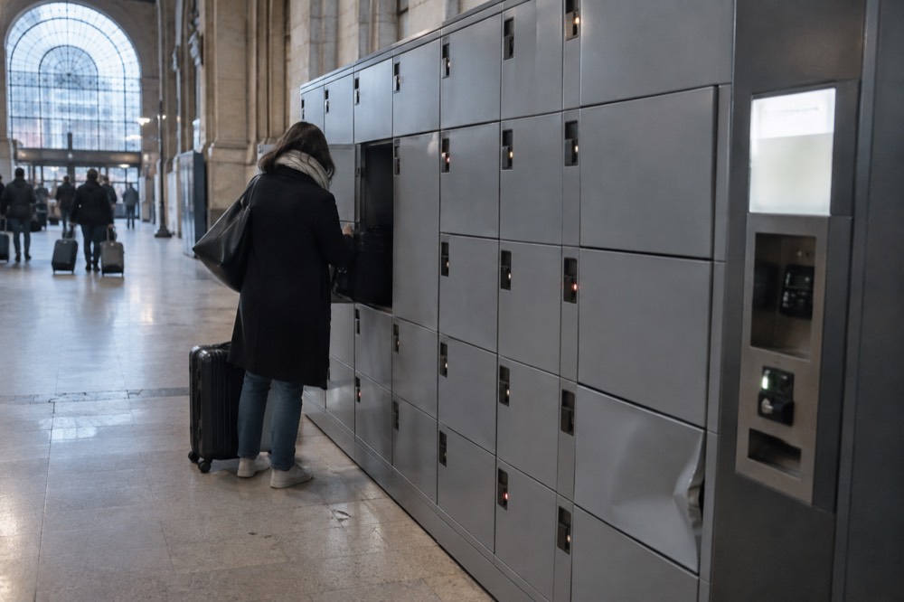 Bank of self-service luggage lockers in a station corridor with a payment terminal