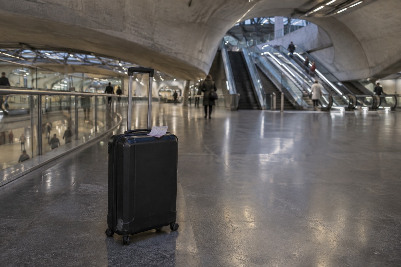 A suitcase on an empty airport terminal walkway near Paris under a curved ceiling