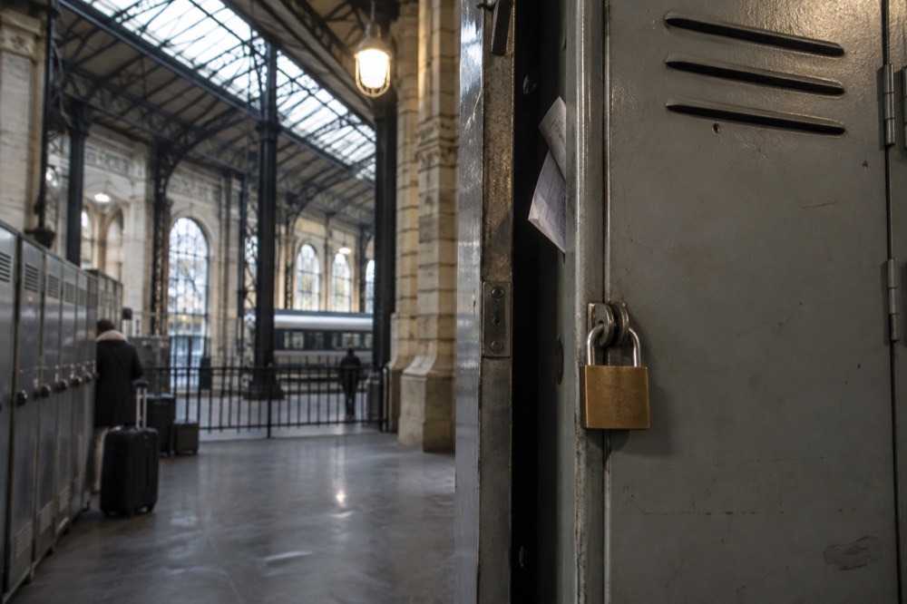 A padlocked locker door with a printed receipt tucked into the frame