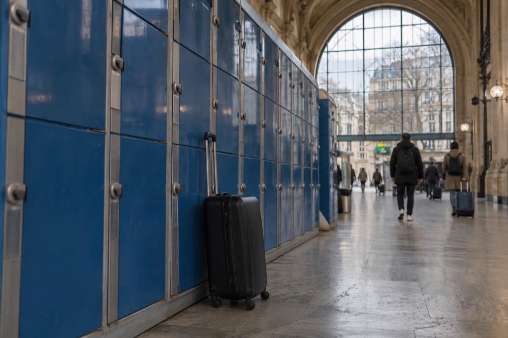 A row of blue luggage lockers inside a Paris train station