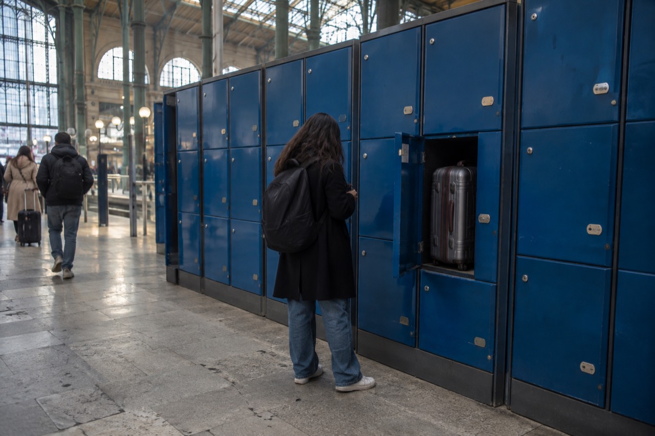 A row of blue luggage lockers inside a Paris train station