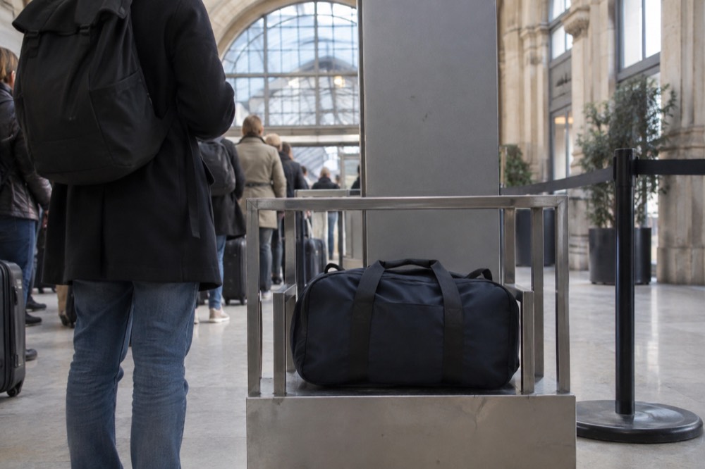 Security checkpoint entrance at a French monument with a bag gauge beside the gate