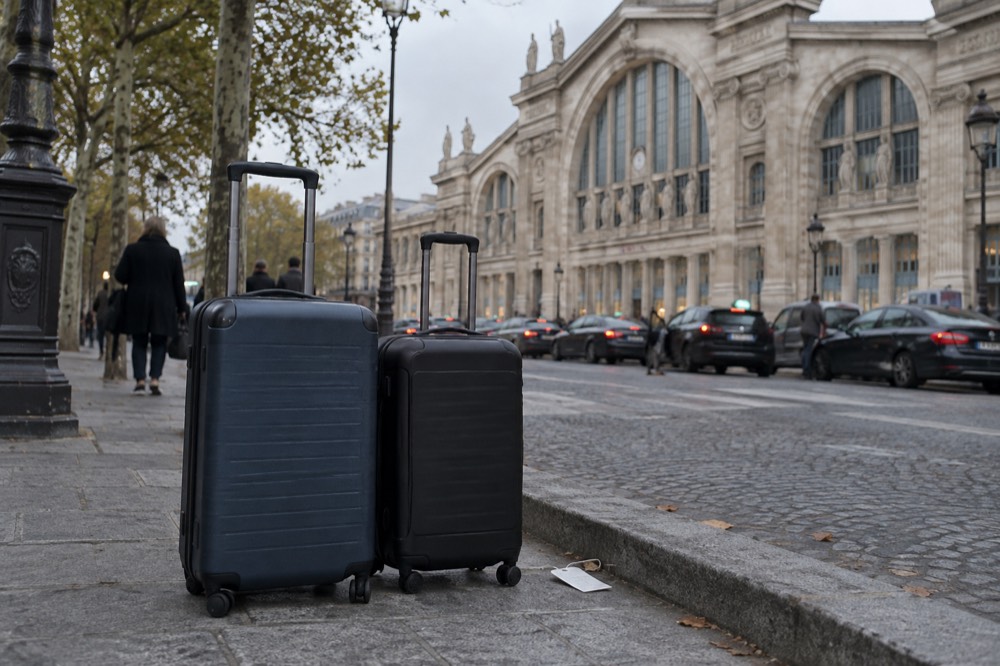 Suitcases on the pavement outside the Gare du Nord facade in Paris